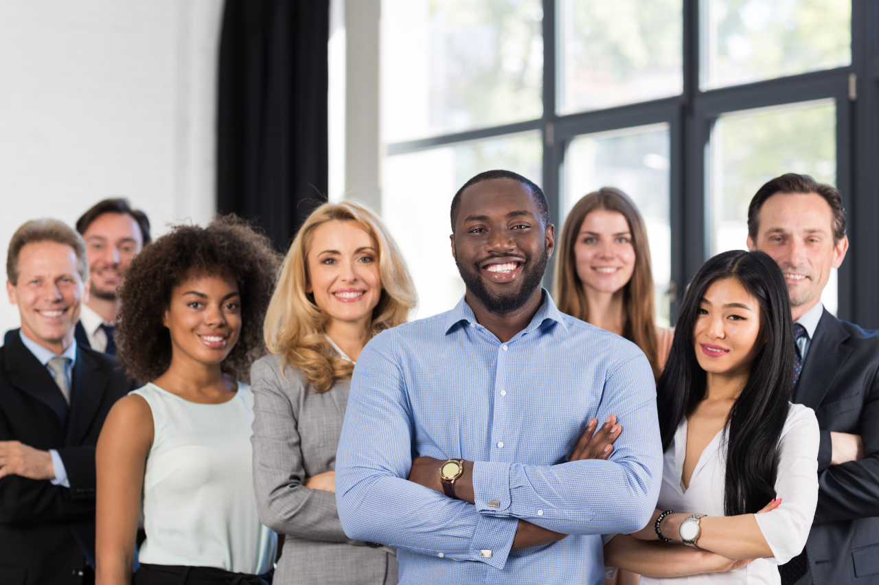 A group of diverse professionals standing together and smiling at the camera.